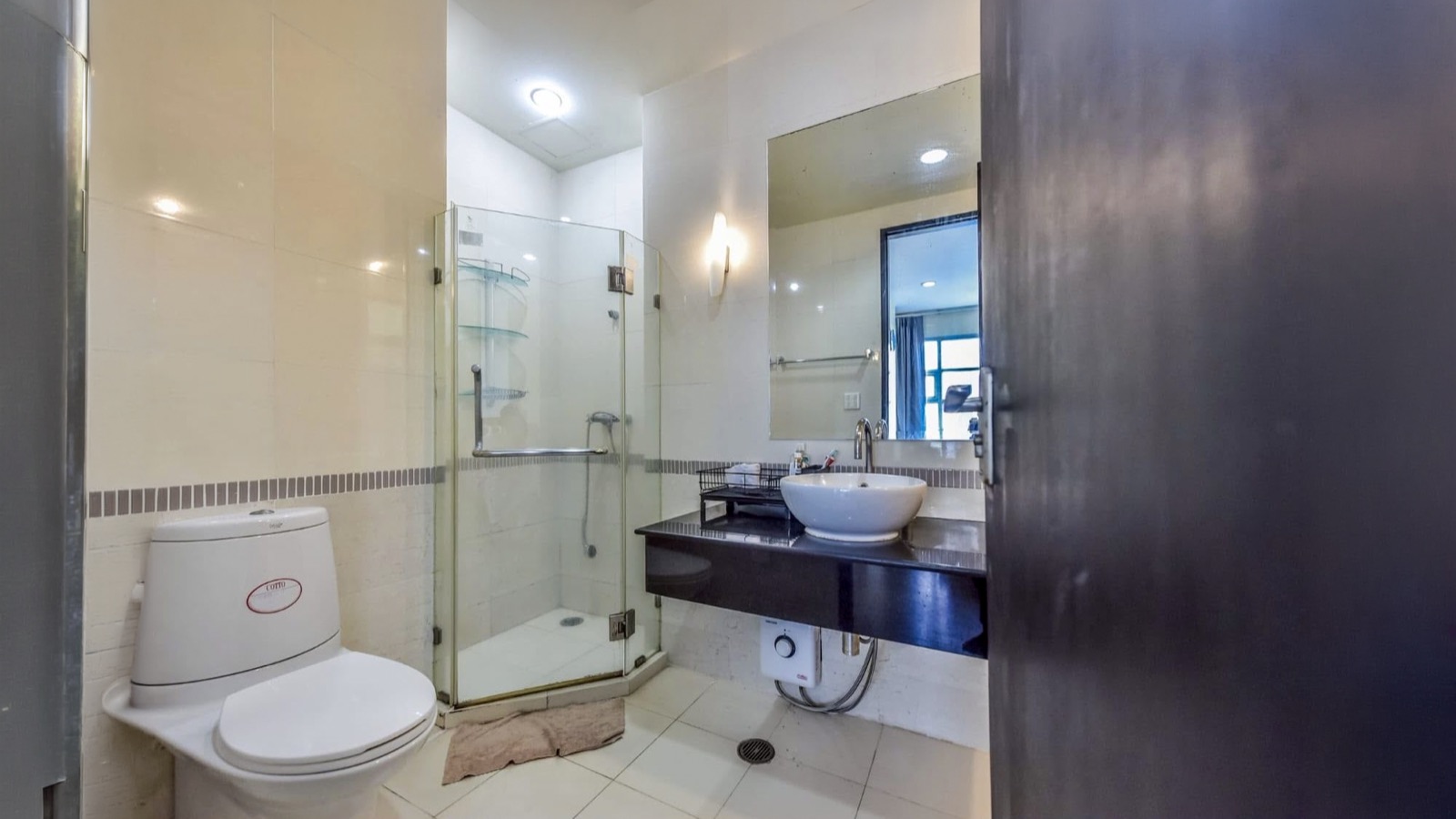 Bathroom with glass shower, toilet, vessel basin, and large mirror