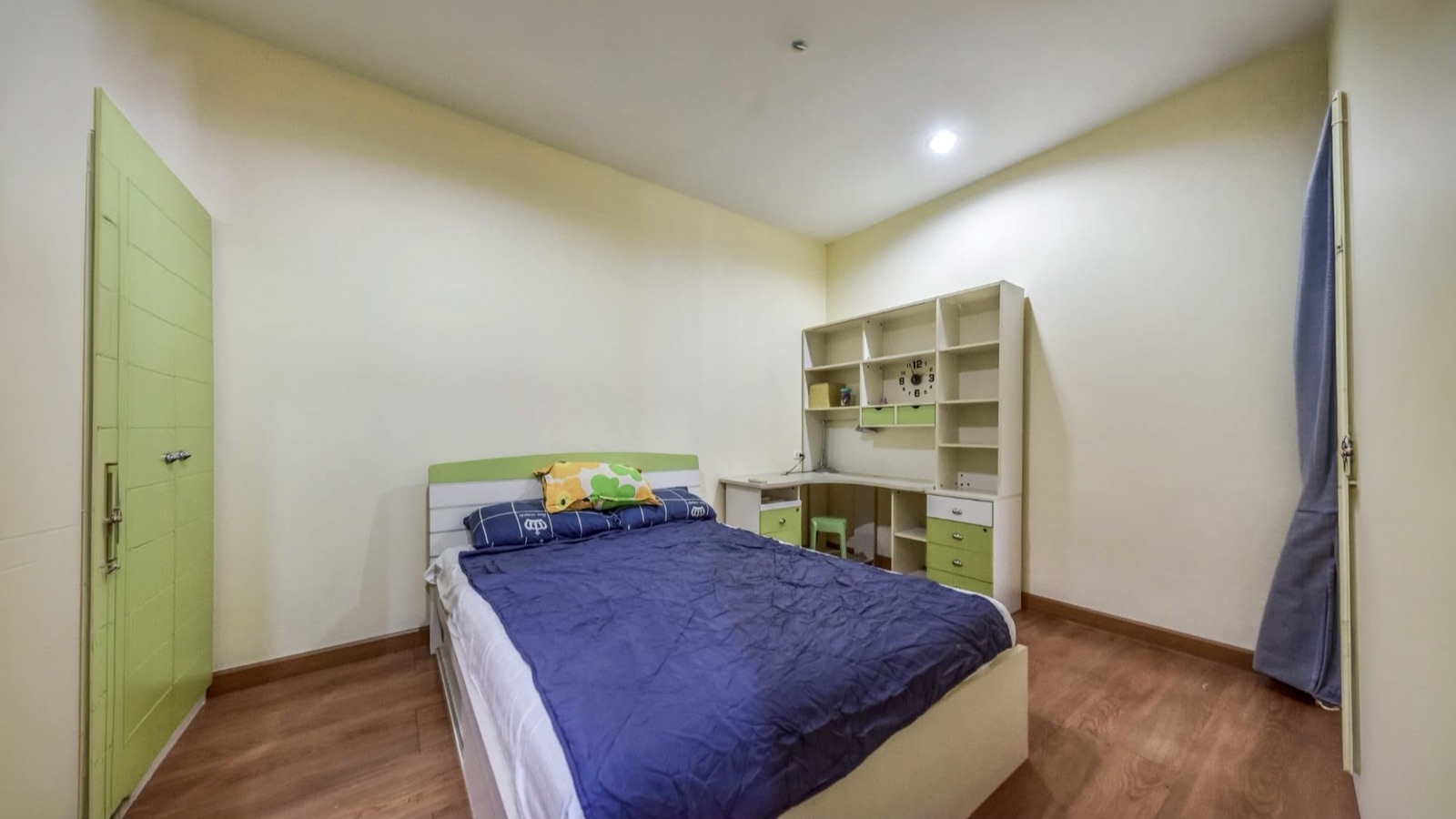Second bedroom with bed, green wardrobe, desk, and built-in shelving
